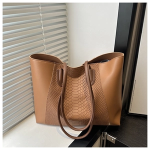 Detail of brown faux leather tote bag with stylish snakeskin texture and large capacity