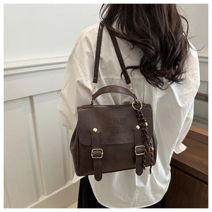 Detail of dark brown retro backpack with textured faux leather and gold buckles