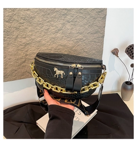 Détail du sac banane noir texture crocodile avec chaîne dorée et emblème de cheval