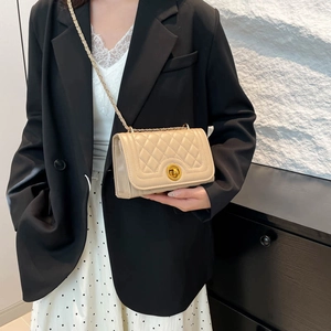 Chic beige quilted crossbody bag with gold chain strap on professional model outfit