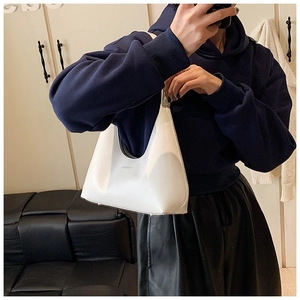 Detail of white minimalist crescent hobo bag with small black lettering logo