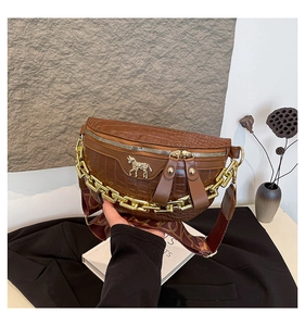 Détail du sac de poitrine marron foncé à motif crocodile avec logo et chaîne dorés