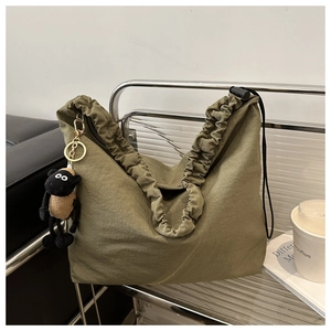 Detail of olive green nylon tote with pleated texture and black drawstring clasp
