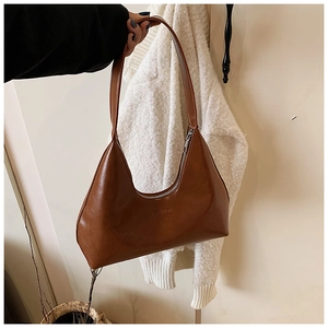 Detail of caramel brown crescent hobo bag in soft leather with metal zipper closure