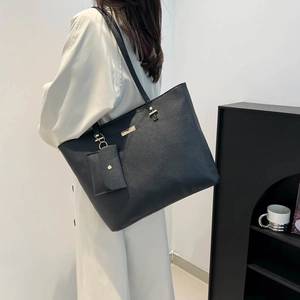 Minimalist black faux leather tote bag with matching pouch for stylish office commuting