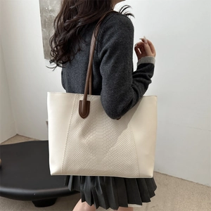 Minimalist beige tote bag with snakeskin texture panel and slim brown straps