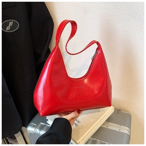 Close-up of a glossy red hobo bag with silver zipper and premium leather texture