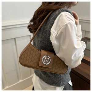 Détail du sac baguette marron vintage avec logo M argenté et motif monogramme