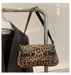 Detail of leopard print shoulder bag with vintage gold horsebit buckle on black strap
