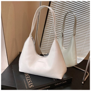 Detail of white leather hobo bag with JIASHIQING logo and metal zipper on black art books