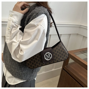 Détail d'un sac d'épaule vintage marron avec imprimé monogramme et boucle en métal
