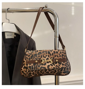 Detailed view of a leopard print underarm bag with a vintage gold horsebit buckle