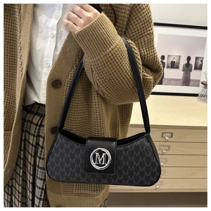 Gros plan sur le sac baguette noir avec boucle logo M argentée et imprimé vintage chic
