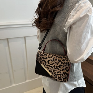 Chic leopard print crossbody bag with gold metal trim and adjustable strap shown on model