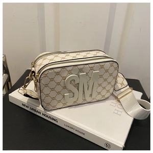 Détail du sac caméra blanc à monogramme avec logo SM 3D et large bandoulière tissée