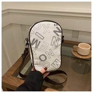 Detail of white leather shoulder bag with black letters and brown fabric strap hooks