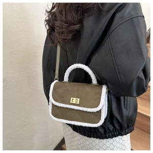 Detail of olive green quilted square bag with plush fleece trim and metal twist lock closure