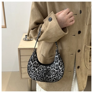 Gros plan du sac croissant à imprimé léopard avec texture tissu et zip en métal
