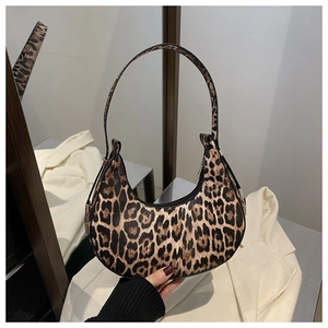 Sac croissant à imprimé léopard tenu à la main, texture élégante de motif animalier