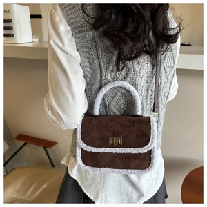 Détail du sac à main en daim matelassé marron foncé avec bordure en fausse fourrure blanche