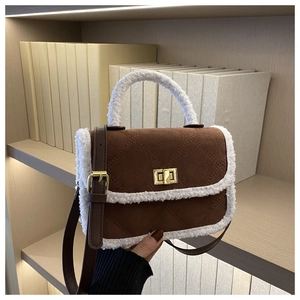 Detail of dark brown quilted crossbody bag with white faux fur trim and gold twist lock