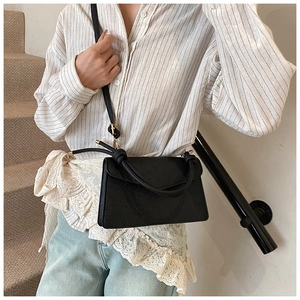 Chic black square crossbody bag with vintage embossed texture and a knot handle design