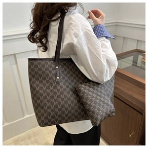 Détail d'un grand sac cabas avec imprimé à motif M et pochette assortie pour le bureau