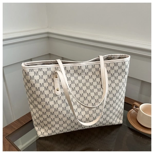 Détail de l'imprimé monogramme M et des rivets dorés sur le grand sac cabas élégant