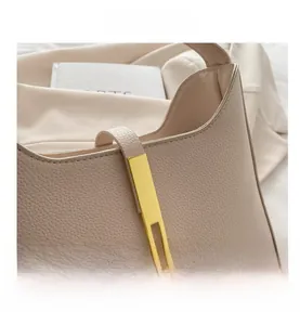 Détail du sac demi-lune en cuir crème avec texture grainée et boucle en métal doré