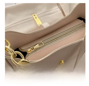 Détail du zip fluide et du cuir beige texturé sur un sac à main en forme de croissant