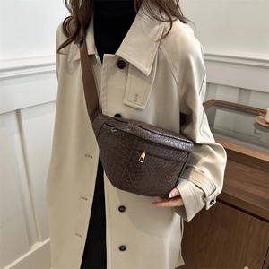 Retro dark brown woven crescent chest bag with adjustable strap worn by a model