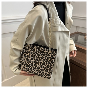 Sac fourre-tout à imprimé léopard avec bandoulière en chaîne porté sur un trench-coat