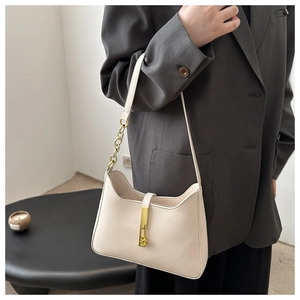 Détail du sac demi-lune crème montrant la boucle dorée et la bandoulière en chaîne