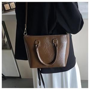 Détail du sac cabas en similicuir marron café avec texture plissée et finitions dorées