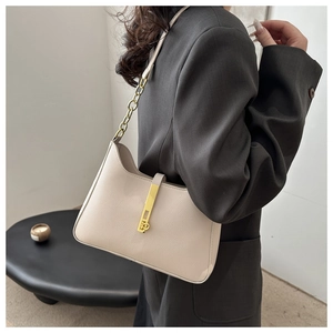 Détail d'un sac bandoulière en cuir grainé avec boucle dorée et bandoulière chaîne