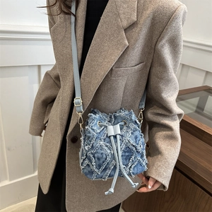 Stylish light blue denim bucket bag with distressed texture and drawstring closure