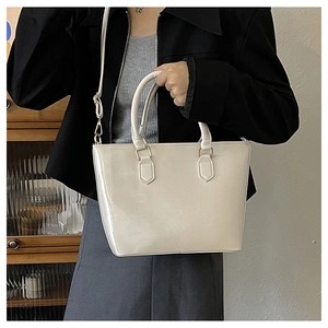 Détail d'un sac seau blanc crème minimaliste avec finition brillante et double poignée