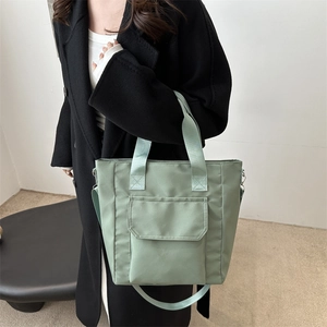 Minimalist light green tote bag with front flap pocket and adjustable shoulder strap