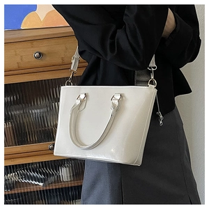 Détail d'un sac seau blanc en cuir verni brillant avec finition effet miroir chic