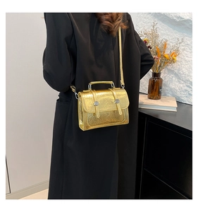 Detailed view of a gold wrinkled texture handbag with silver metallic hardware and top handle