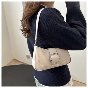 Détail du sac baguette blanc crème avec boucle argentée sur la bandoulière d'épaule