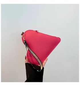 Détail du sac à main cœur rose avec cuir grainé et dragonne tissée colorée élégante