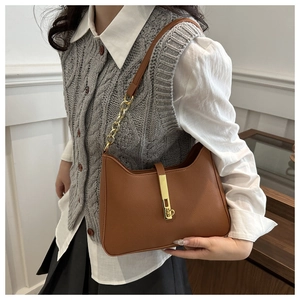 Détail du sac hobo en cuir marron avec boucle dorée et bandoulière en chaîne élégante