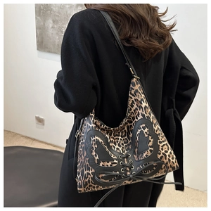 Detail of leopard print tote bag with black leather butterfly applique and lace-up design