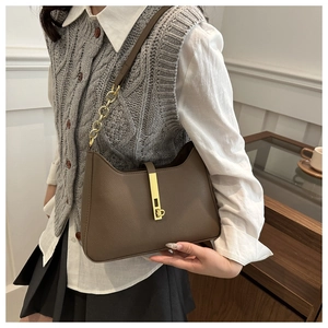 Détail de la texture cuir litchi marron foncé et du fermoir doré sur ce sac croissant