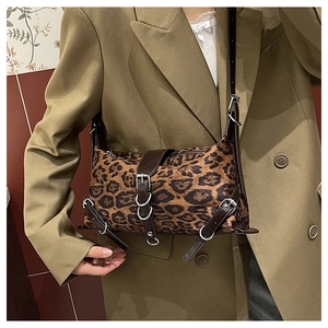 Dettaglio borsa leopardata con fibbie argentate indossata su un blazer color albicocca