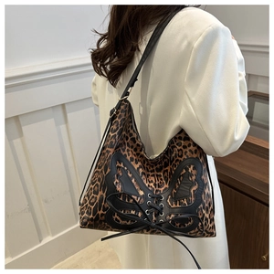 Detail of leopard print tote bag featuring a leather butterfly stitch and corset lacing
