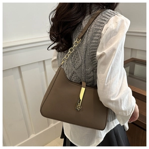 Détail du sac croissant en cuir marron avec boucle dorée et bandoulière en chaîne