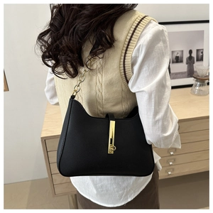Détail du sac croissant noir en cuir grainé avec bandoulière en chaîne dorée élégante