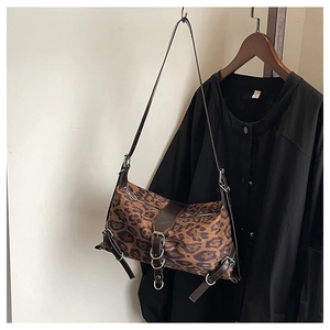 Dettaglio borsa leopardata con tracolla in pelle marrone e fibbie metalliche argento